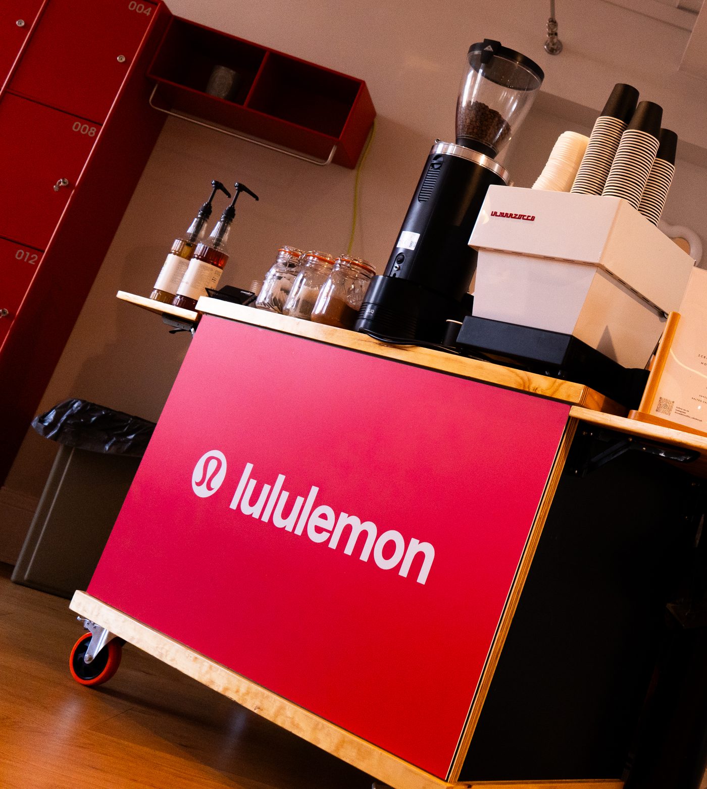 The cart with a custom red branded front panel, grinder and espresso machine on top